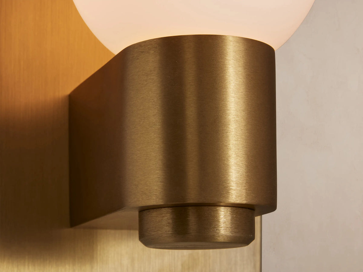 Casen Sconce: Satin brass rectangular wall plate with a cylindrical holder extending forward, supporting an opaque white glass globe.