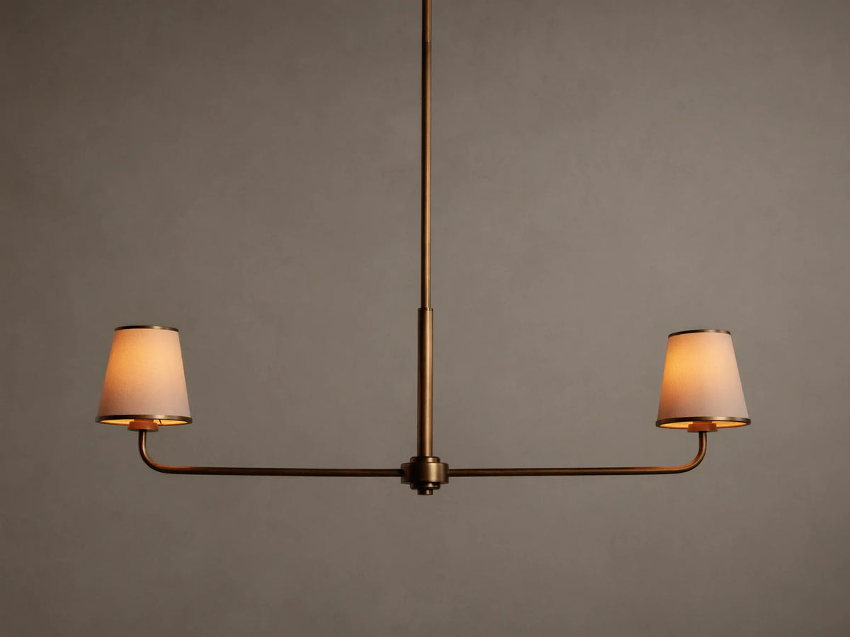 Adria 2-Light Chandelier: Bronze-finished frame with two glowing, tapered off-white fabric shades on a horizontal bar.