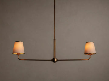 Adria 2-Light Chandelier: Bronze-finished frame with two glowing, tapered off-white fabric shades on a horizontal bar.