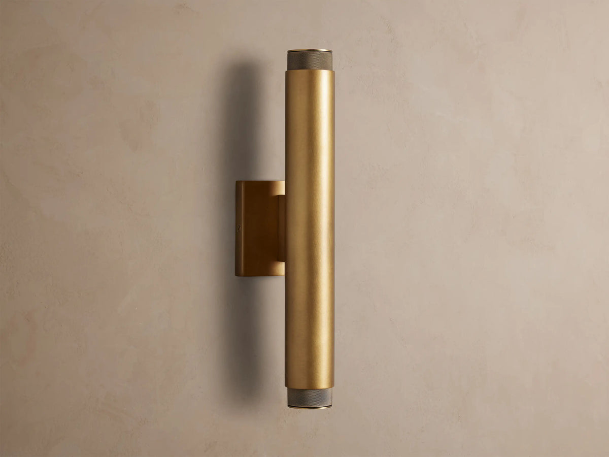 Brass Spotlight Outdoor Sconce, cylindrical, mounted vertically on a wall, with dark knurled end caps.