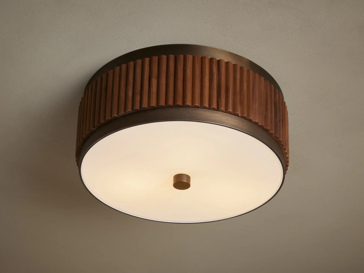 A ceiling light fixture with a ribbed wooden band encircling a frosted glass diffuser, emitting a warm glow.