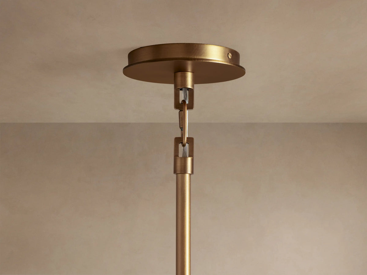 Adria Pendant light, showing a warm glowing fabric diffuser, dark bronze metal trim, and pleated cream shade.