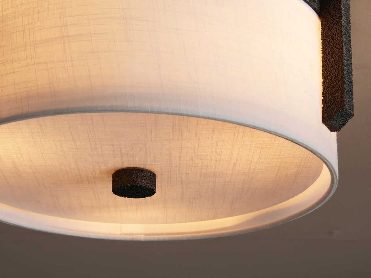 Emmet Flush Mount light with round white linen shade and textured dark bronze/black frame, mounted on a light ceiling.