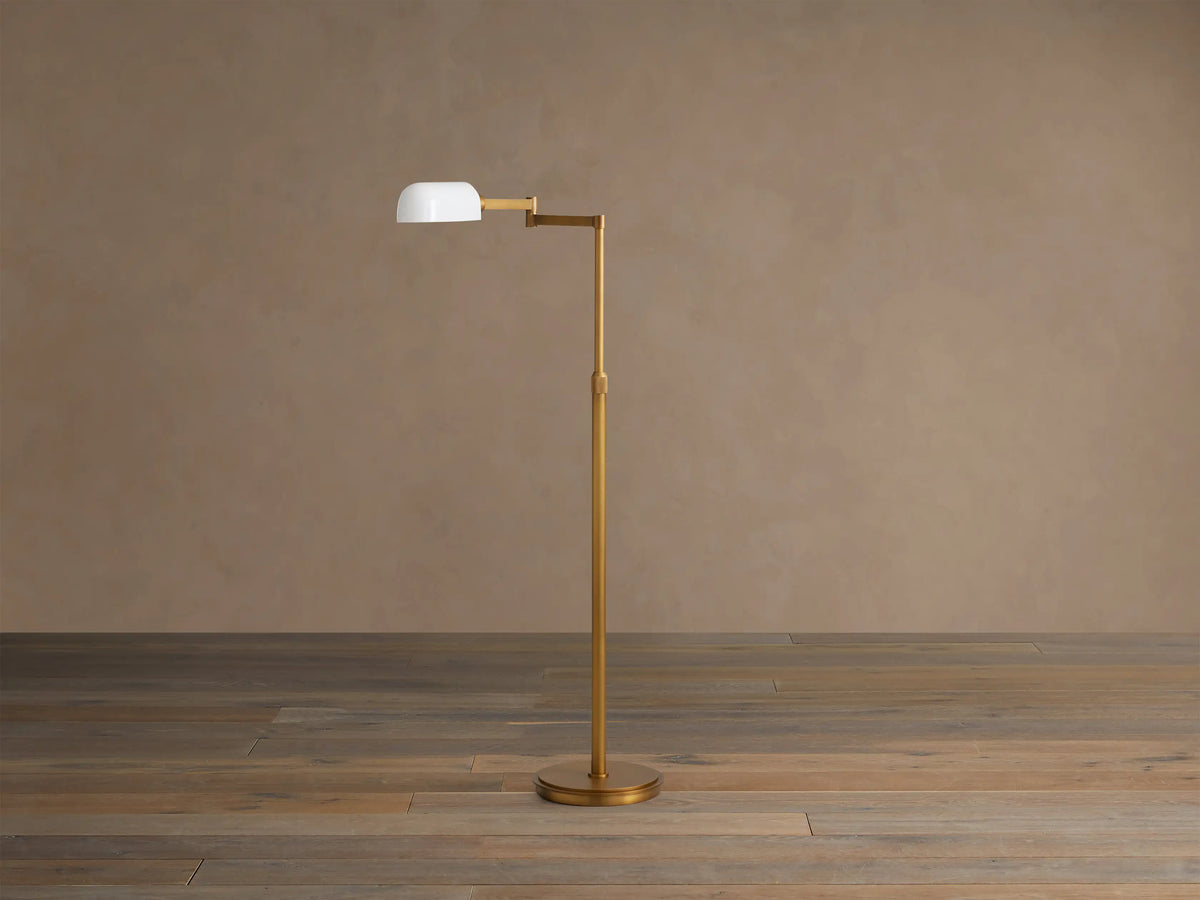 Close-up of Zayd Swing Arm Floor Lamp: glowing white opal shade, brass articulated arm, and fluted adjustable pole.