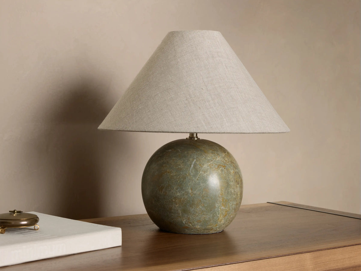 Front view of a table lamp featuring a spherical green marbled base and a light beige linen tapered lampshade.