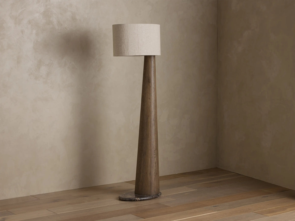 Close-up of the illuminated beige textured linen oval lamp shade, glowing warmly.