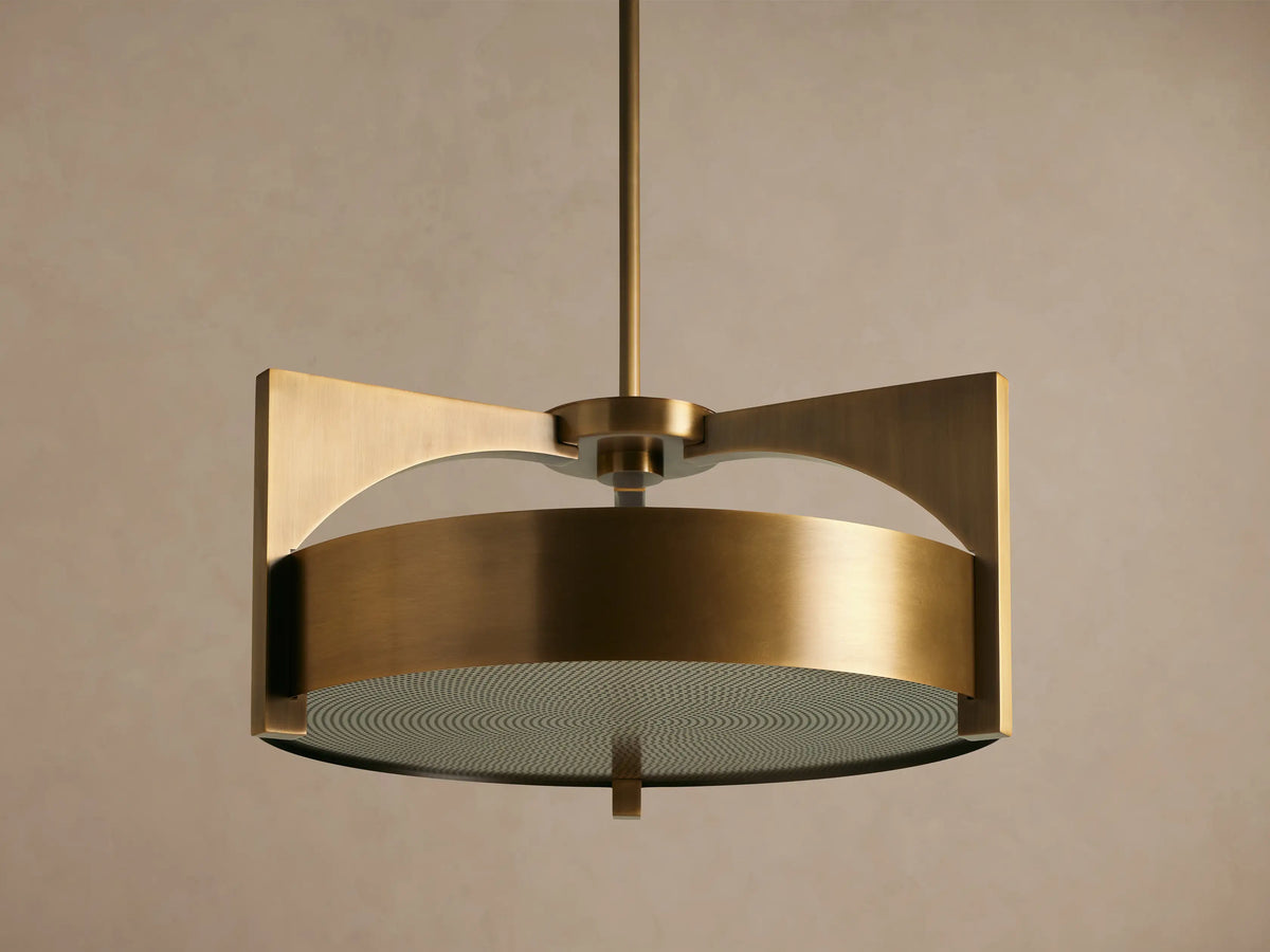 Burnished brass Alastair Pendant. Cylindrical shade, angular side supports, and a textured acrylic diffuser, hanging from above.