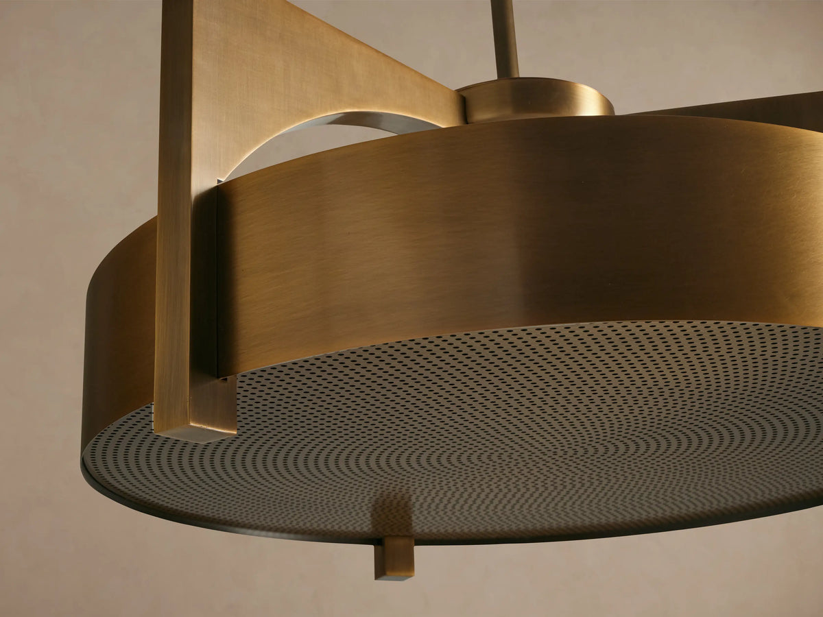 Alastair Pendant, a burnished brass cylindrical light with geometric arcing support arms and a textured circular diffuser, hanging.