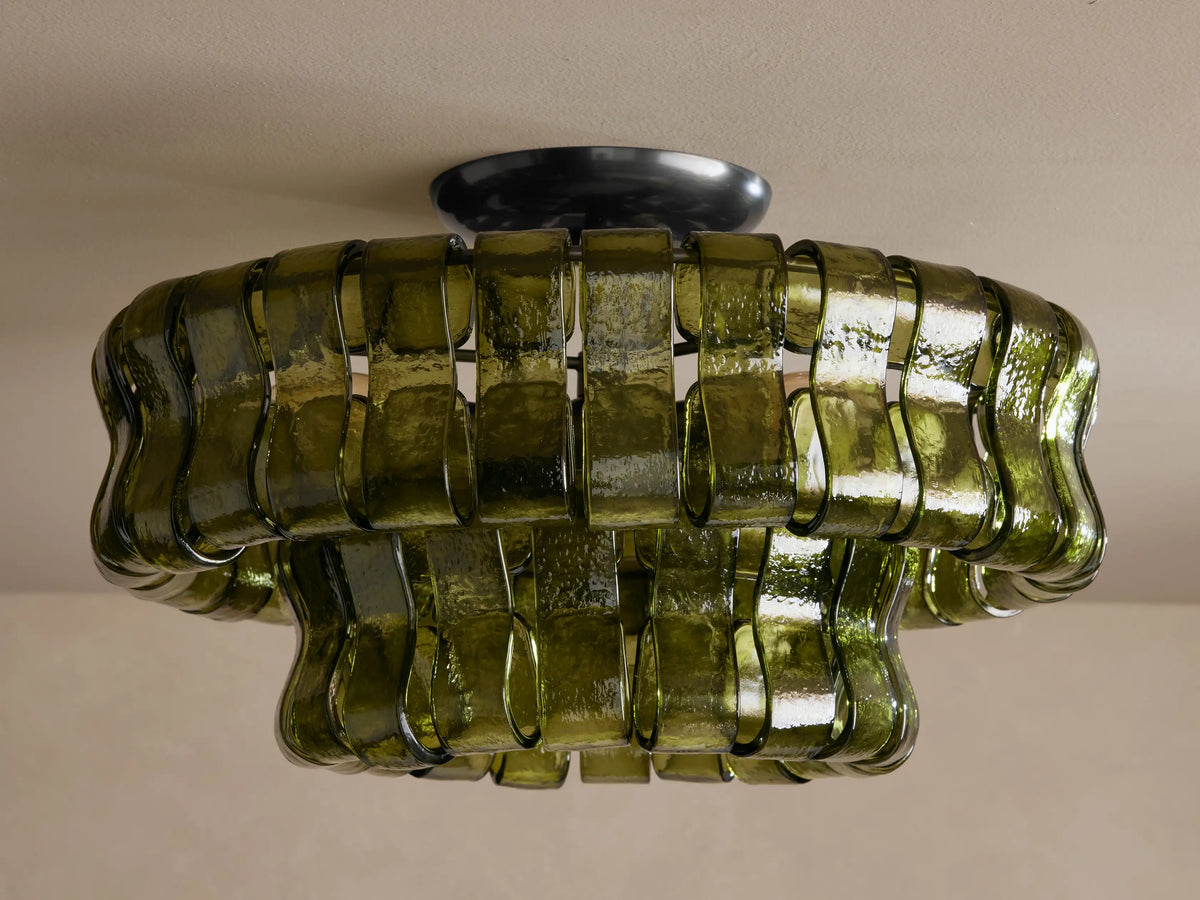 Ghiaccio Flush Mount, a tiered ceiling light made of wavy, dark green textured glass, illuminated with warm glow.