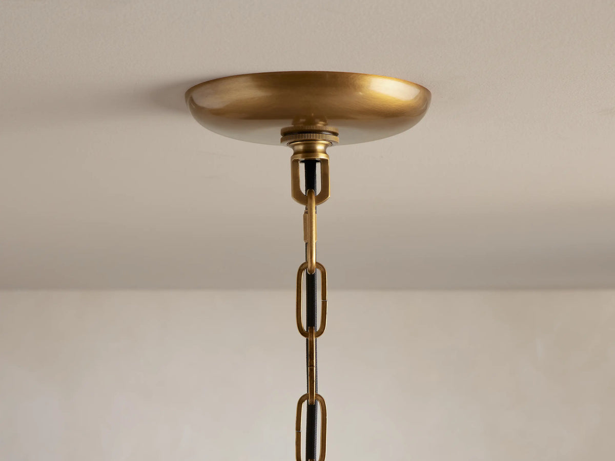 Ghiaccio Round Chandelier, close-up, glowing with warm golden light through multiple layers of wavy, olive green textured glass.