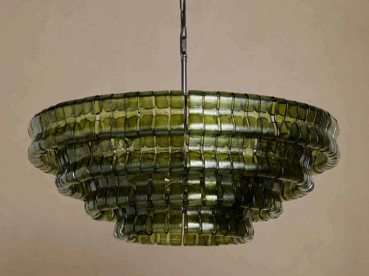 Ghiaccio Round Chandelier: multi-tiered, dark green curved glass with wavy edges, glowing warmly from internal lights.