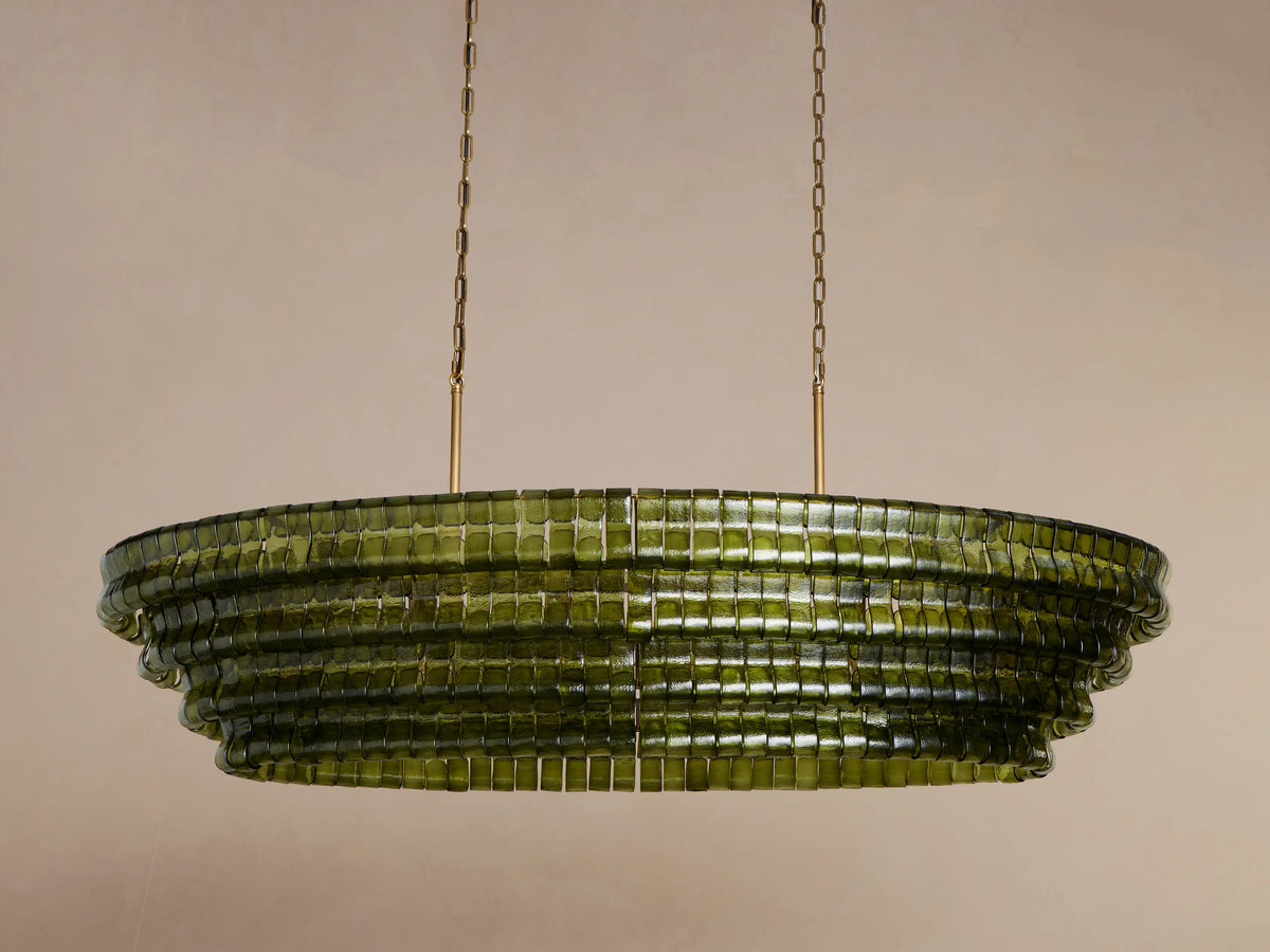 Oval Ghiaccio Chandelier with layered olive-green textured glass, glowing warmly, suspended by gold chains.
