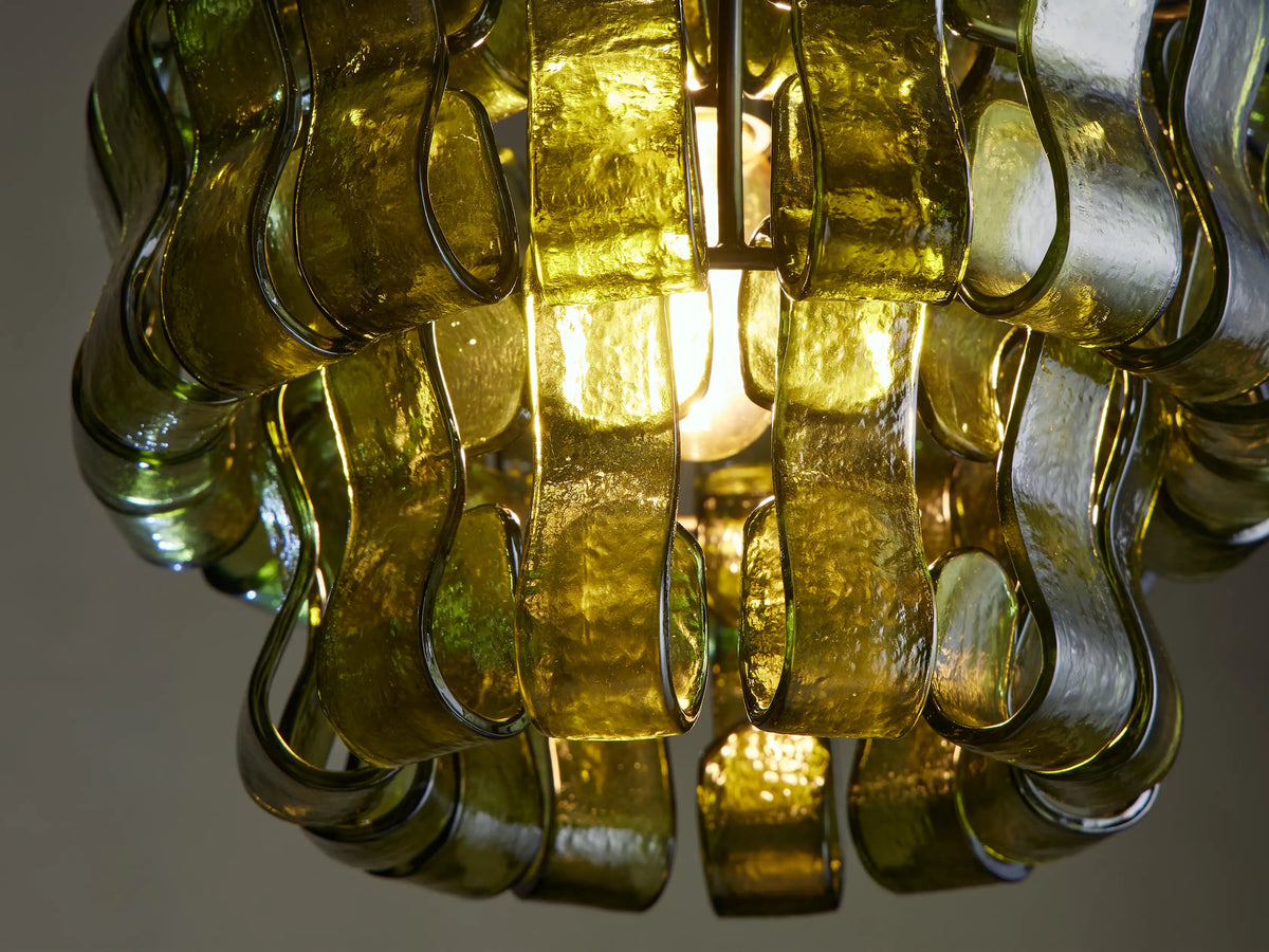 Ghiaccio Pendant, featuring a shade made of layered, wavy translucent green glass pieces, suspended by a dark chain.