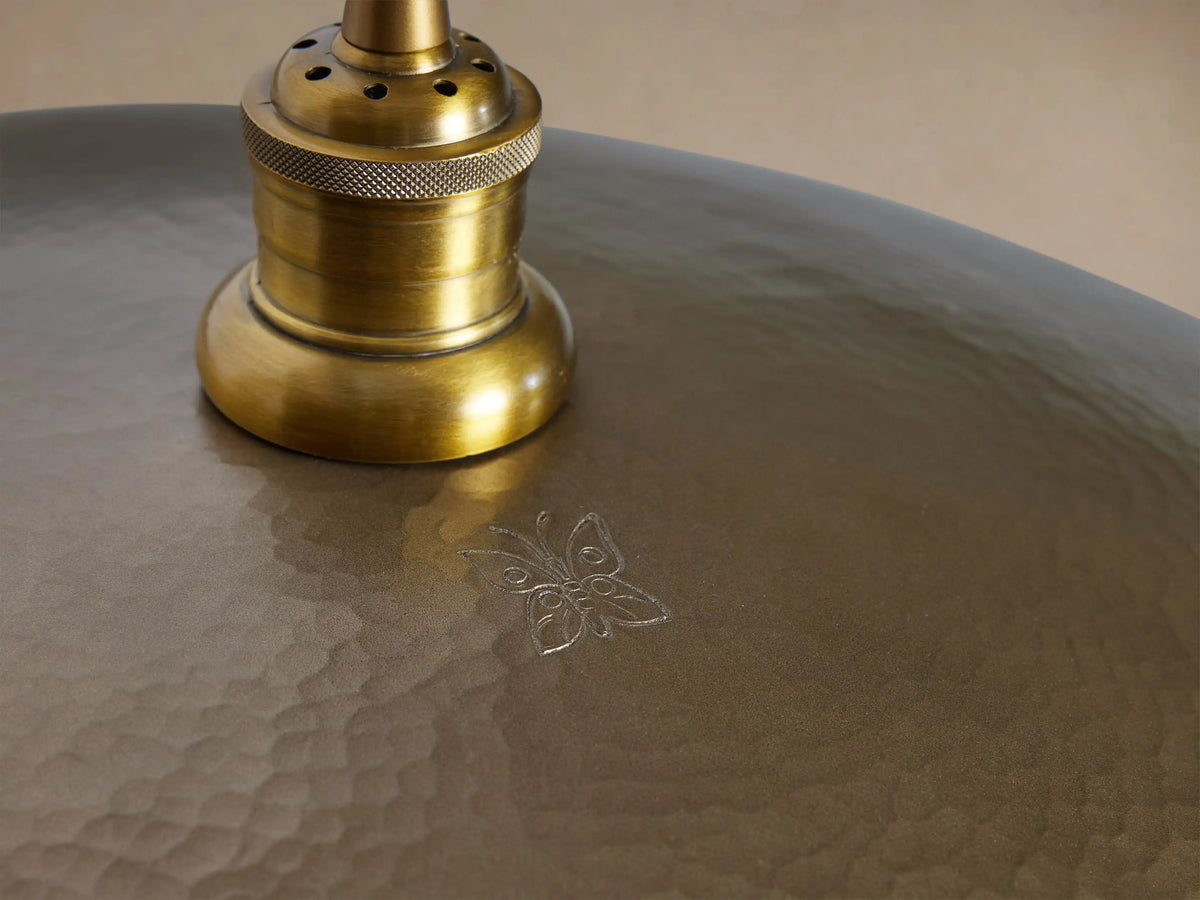 Recycled Metal Fan Pendant: Domed, hammered brass-finished shade with gold hardware, hanging from a black cord.