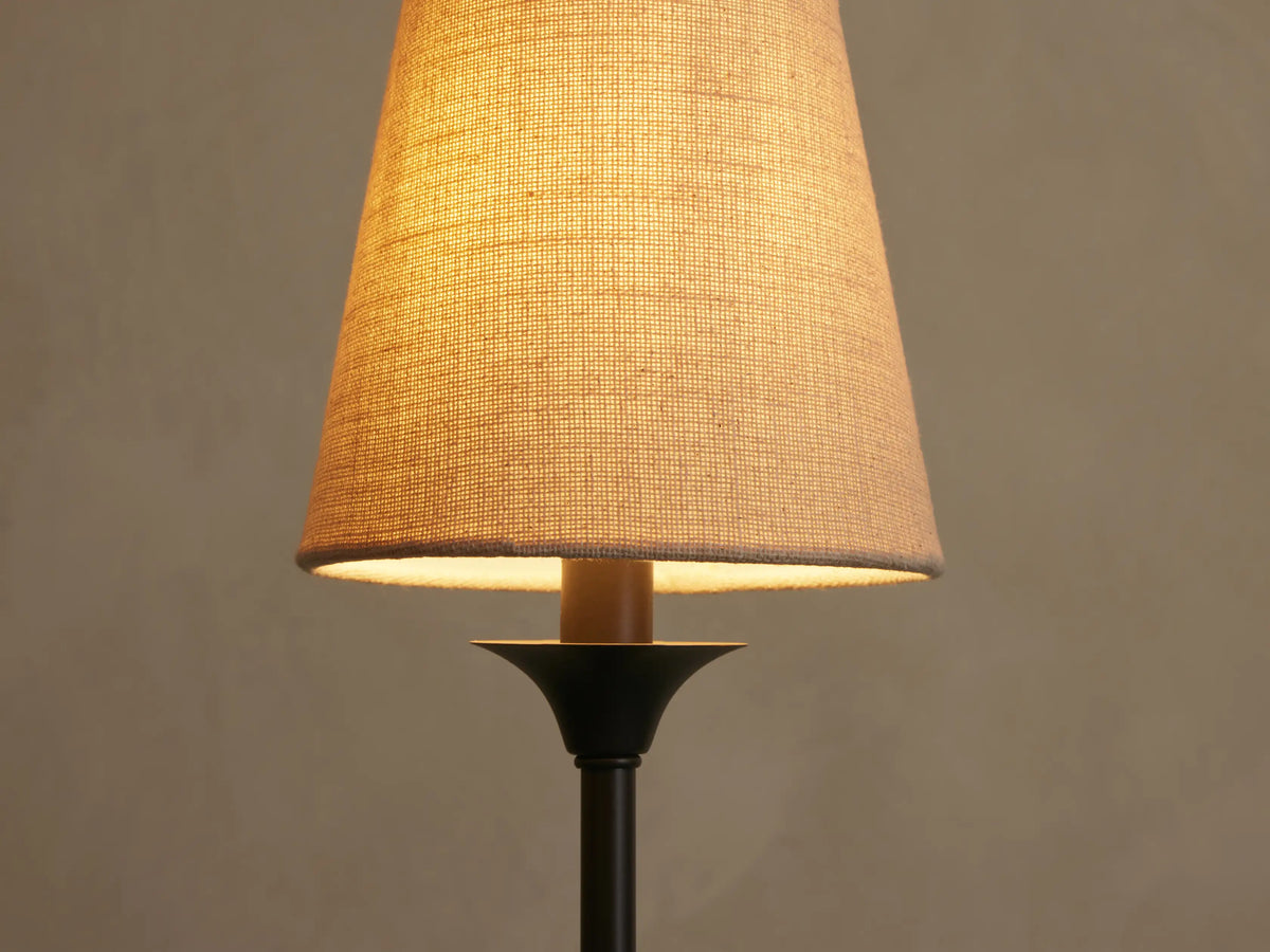 Close-up of Saige Round Chandelier's illuminated off-white textured fabric shade on a dark bronze-finished metal arm.
