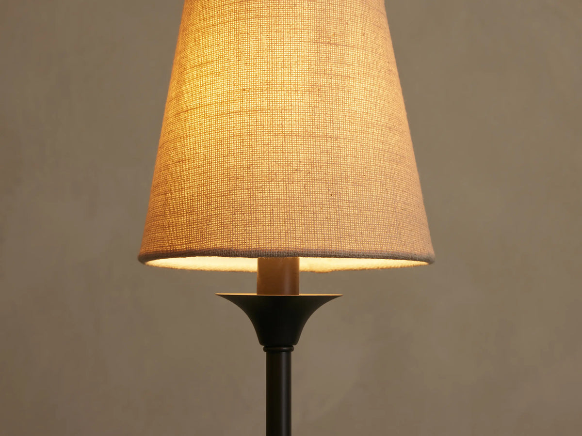 Saige Round Chandelier: Close-up of an illuminated, off-white textured shade over a dark bronze metal component.