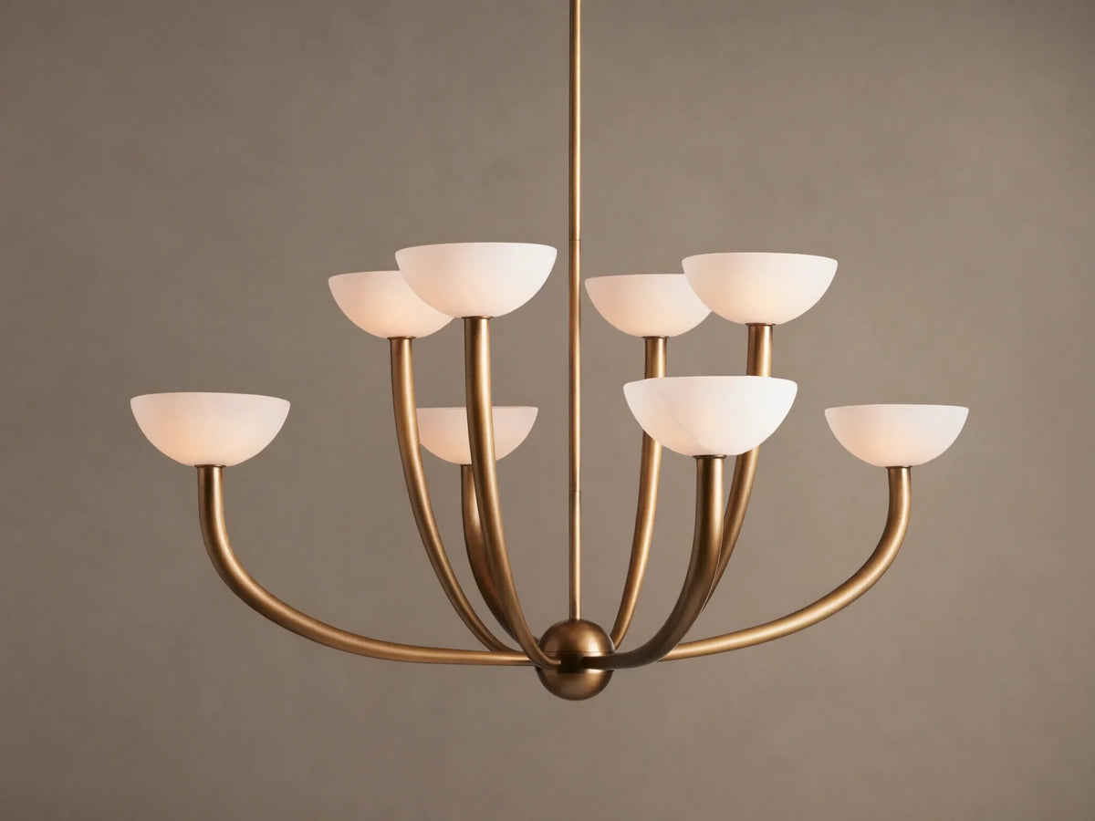Saguaro Chandelier with antique brass frame and 8 upward-facing, glowing white alabaster bowl shades against a neutral background.
