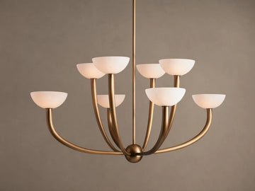 Saguaro Chandelier with antique brass frame and 8 upward-facing, glowing white alabaster bowl shades against a neutral background.