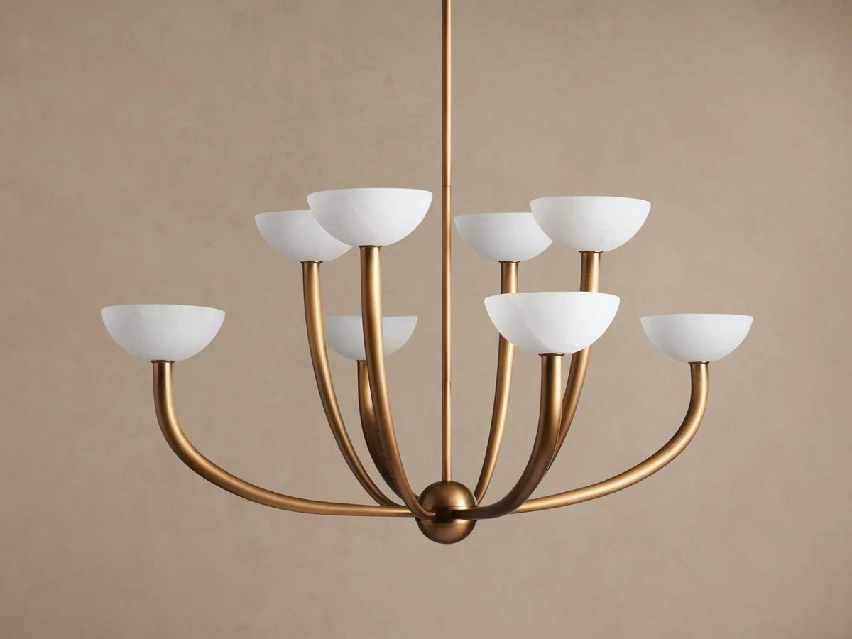 Saguaro Chandelier with antique brass frame and 8 upward-facing, glowing white alabaster bowl shades against a neutral background.