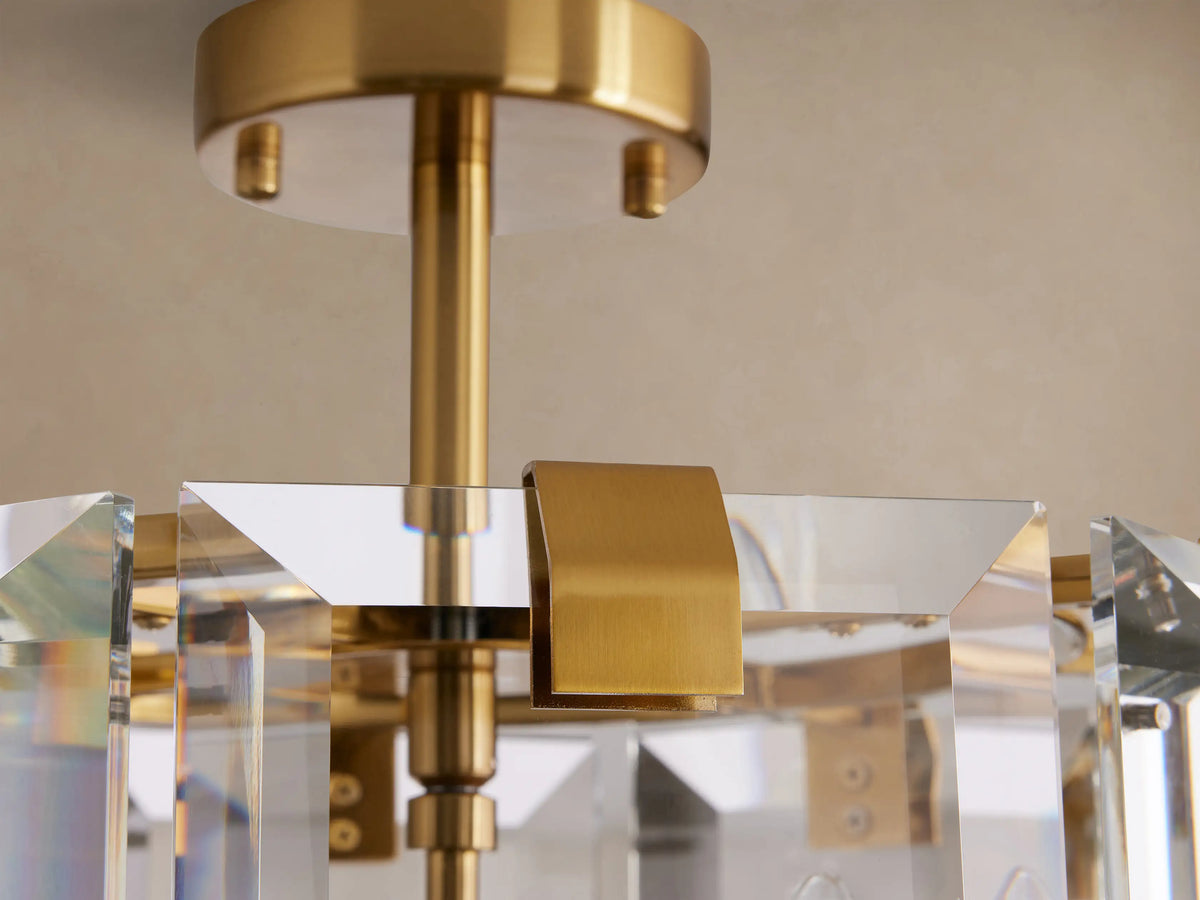 Amaya Flush Mount, clear faceted crystal light fixture with a shiny gold frame, mounted on a light beige ceiling.