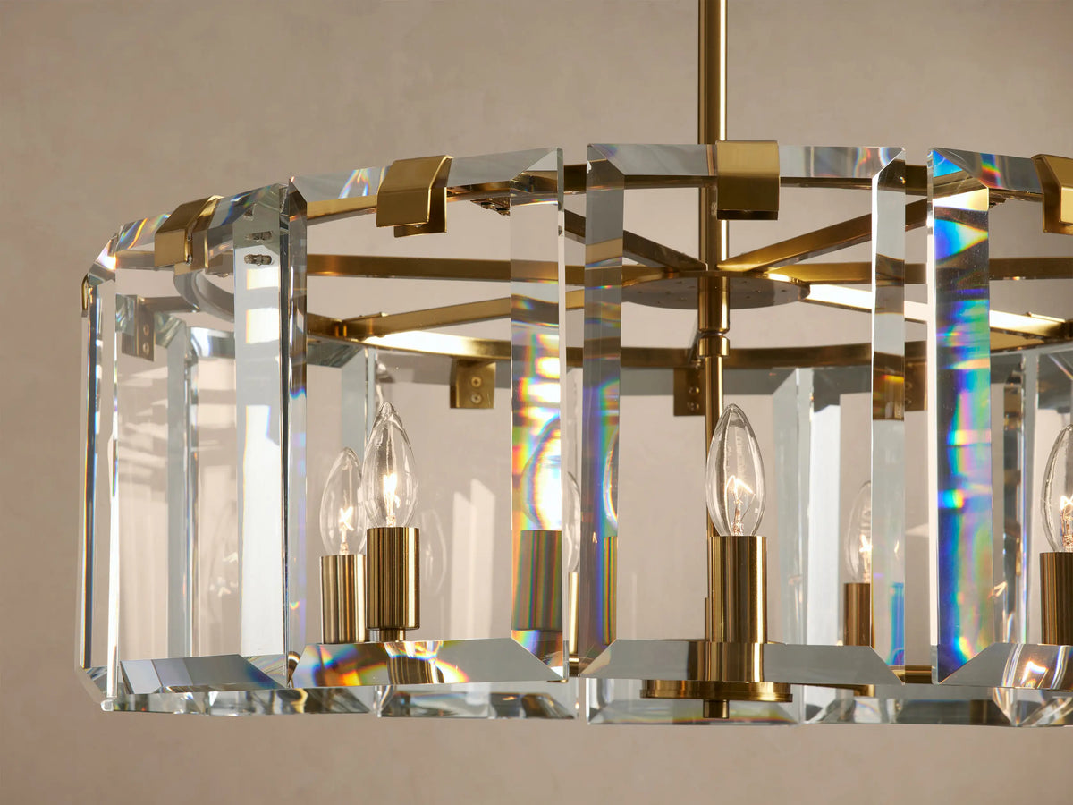 Close-up of Amaya Round Chandelier, clear faceted crystal panels with brass frame, unlit bulbs, rainbow light refractions.