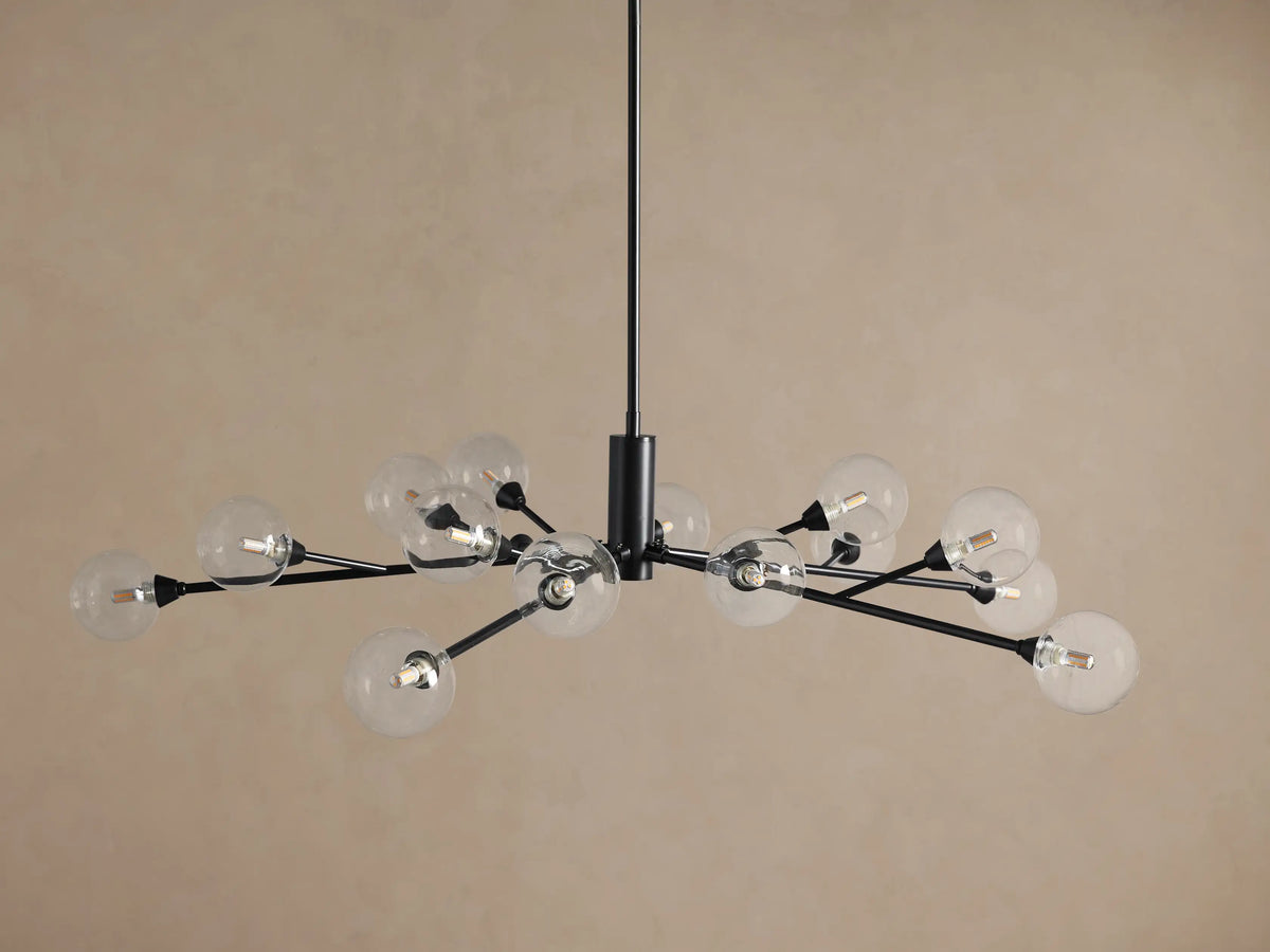Apollo Round Chandelier, dark metal frame with 18 clear spherical glass shades housing LED bulbs, hanging against a tan wall.