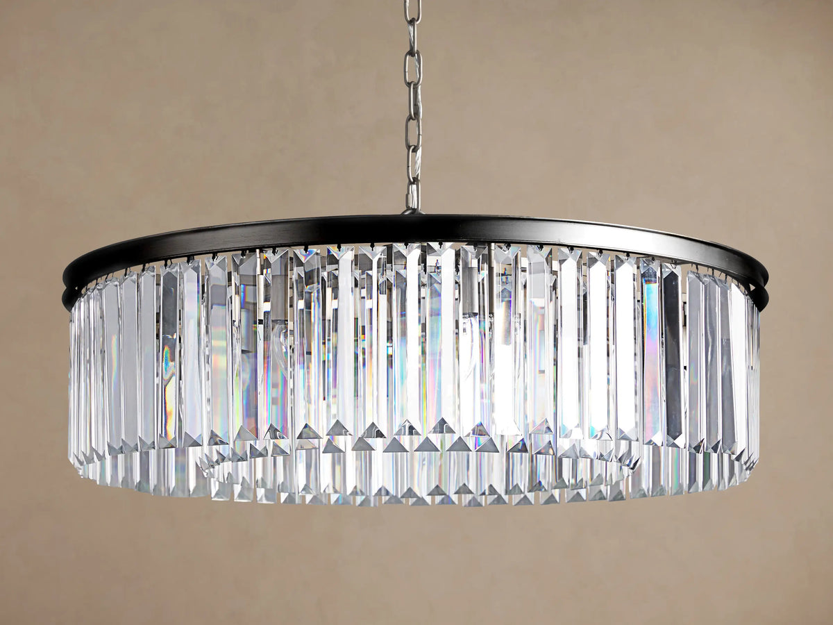 Leyland Round Chandelier with dark metal frame & clear, faceted K9 glass crystals reflecting light, hanging from chain.