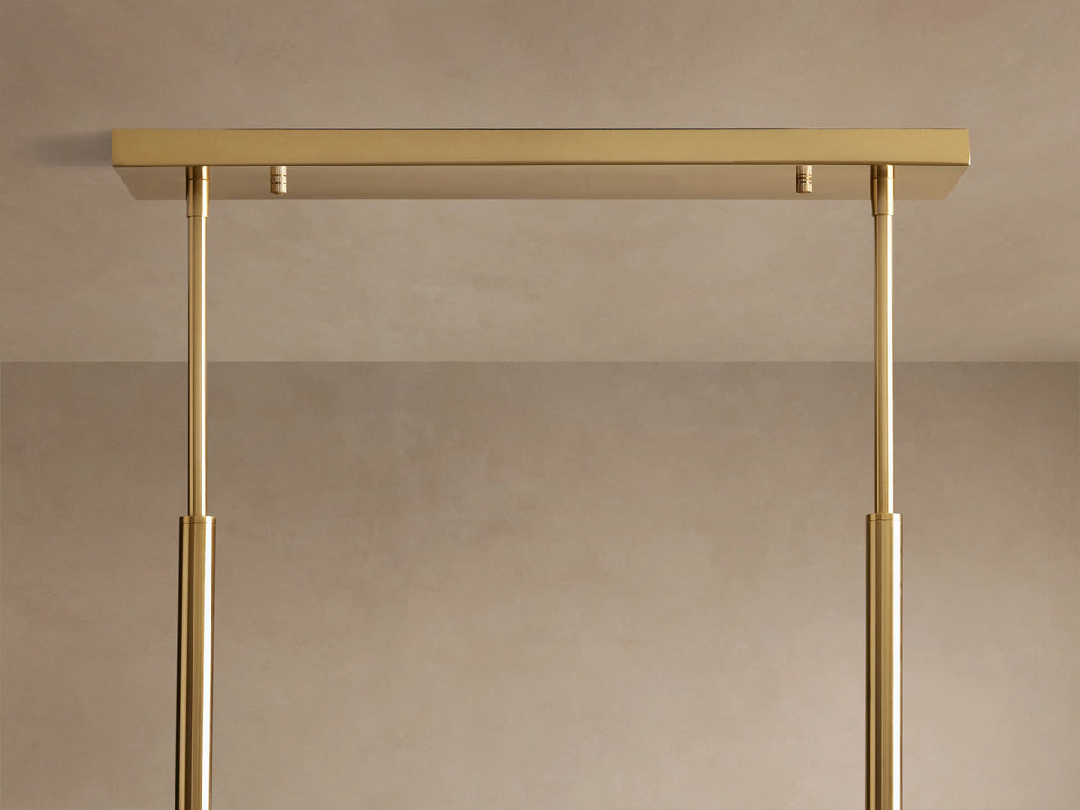 Roscoe Linear Chandelier: Close-up of clear glass globes with illuminated LED bulbs, hanging from brass rods.