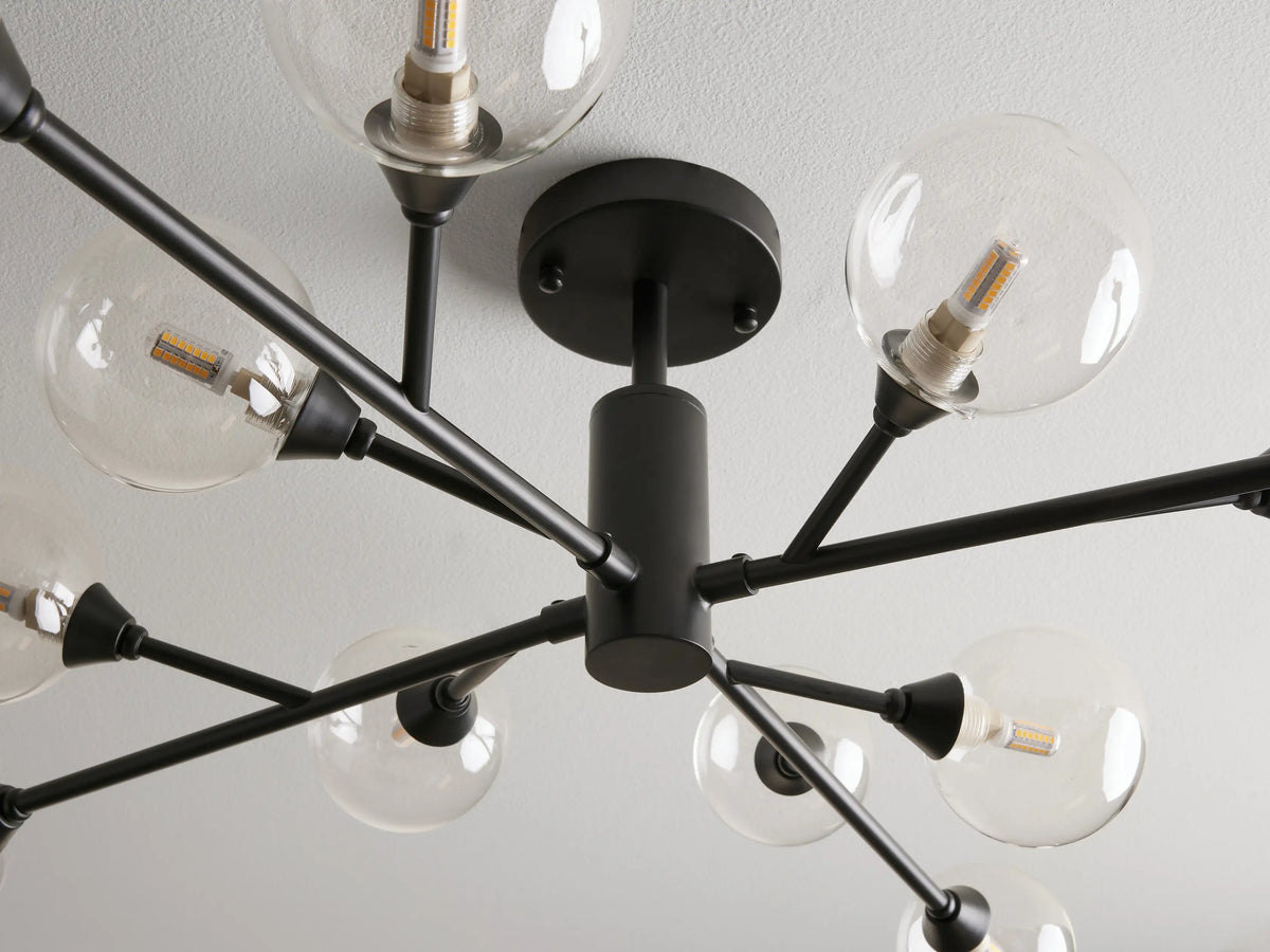 Apollo Flush Mount chandelier with a black iron base, clear glass globe lights, and radiating arms on a white ceiling.