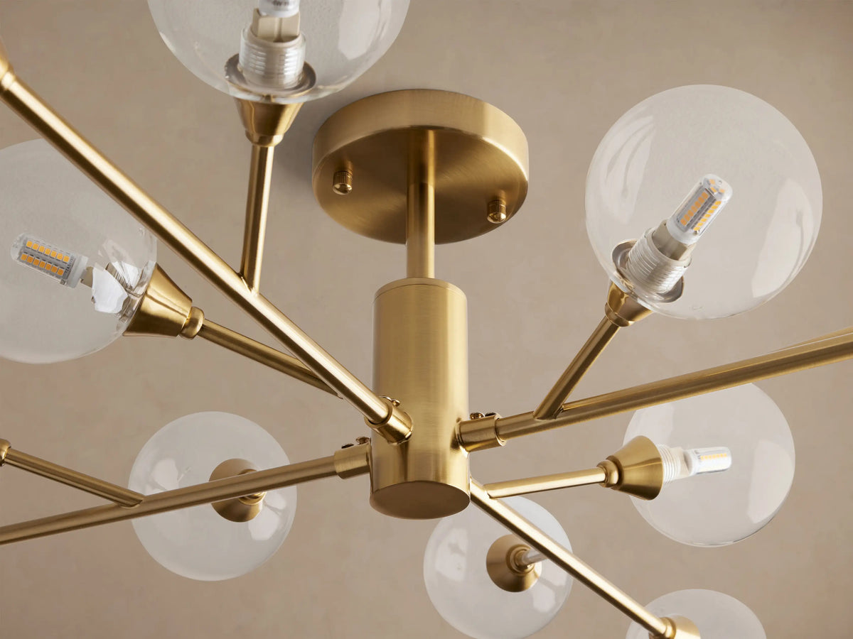 Apollo Flush Mount: Modern polished brass ceiling light with radiating arms, each holding a clear spherical glass globe.