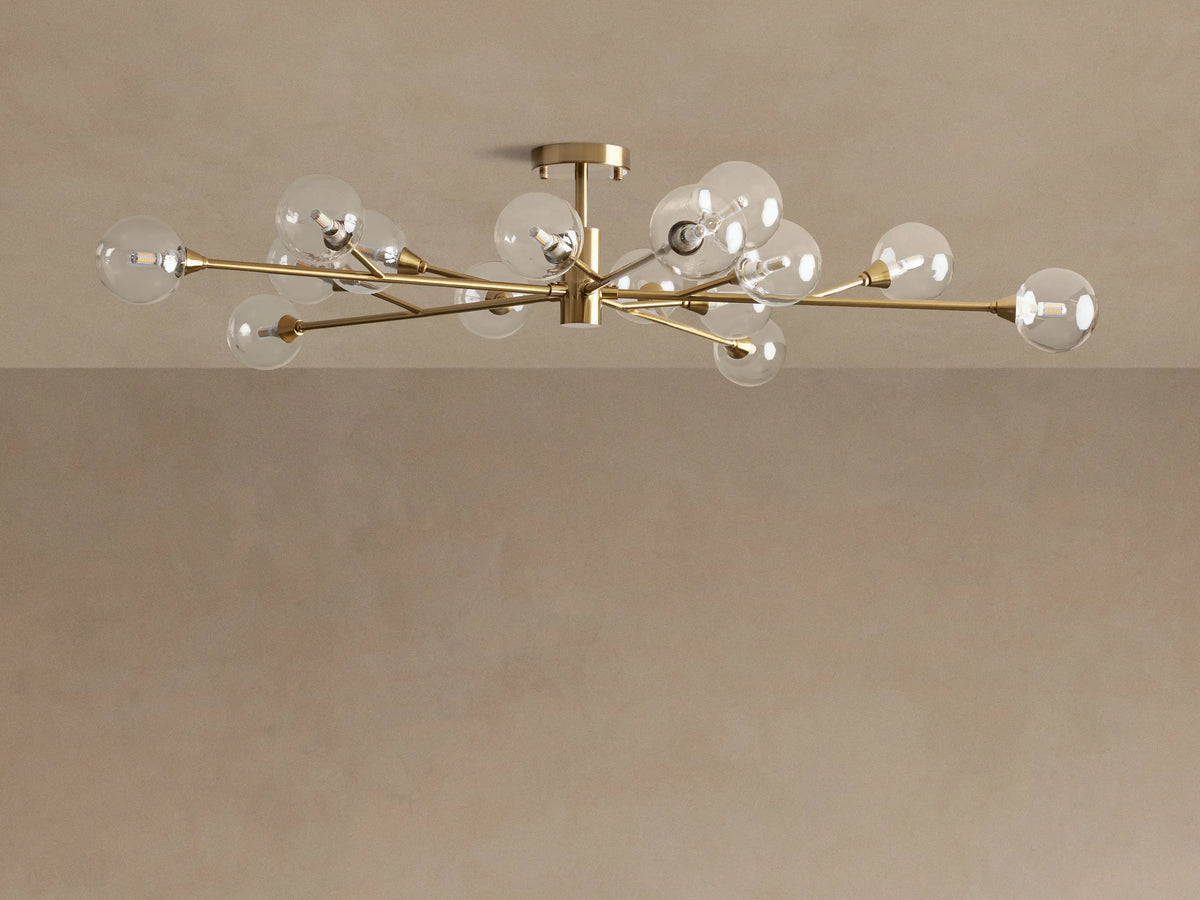 Apollo Flush Mount: A modern gold flush mount ceiling light with radiating brass arms and multiple illuminated clear glass globe bulbs.
