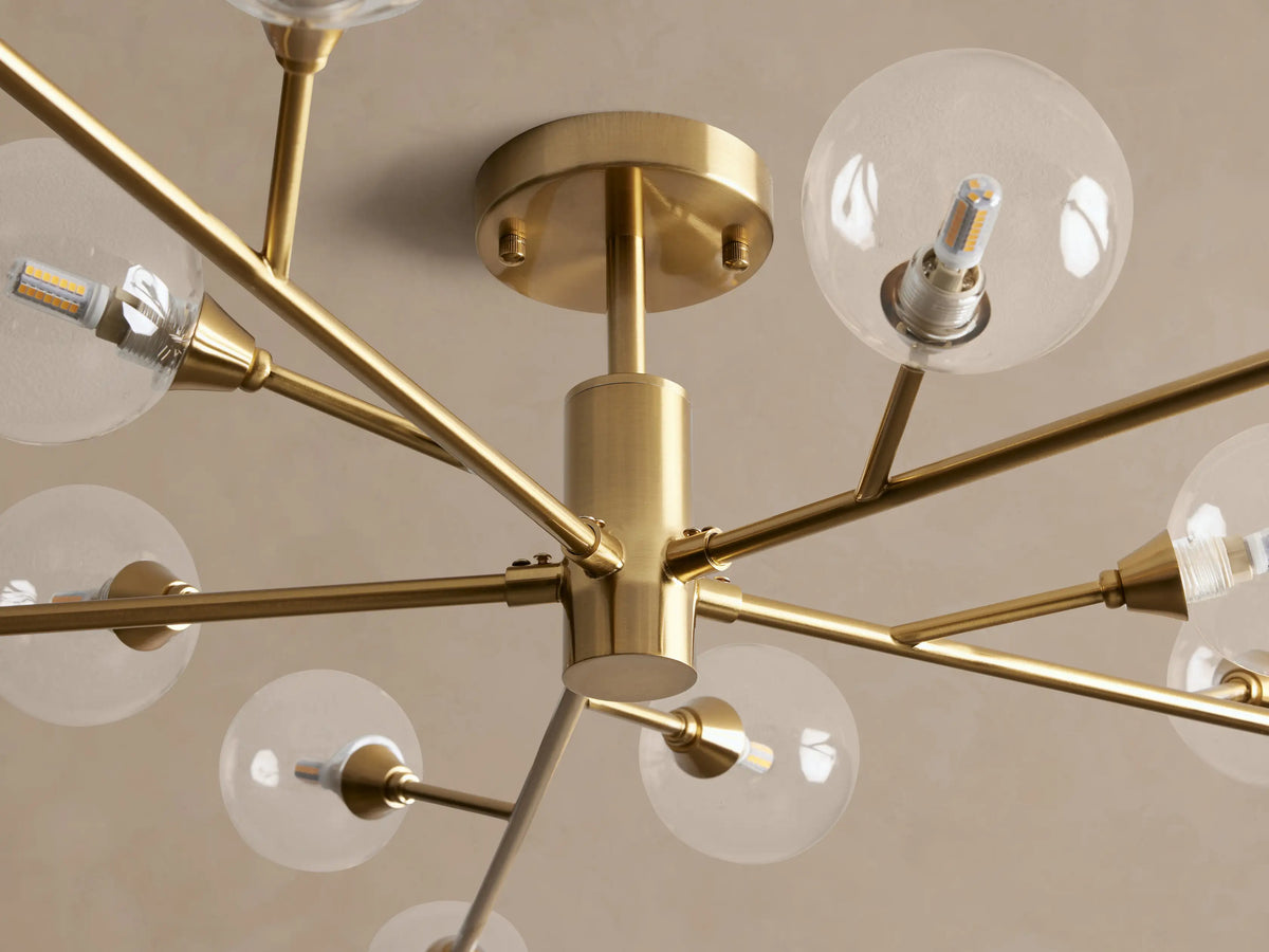 Apollo Flush Mount: Modern gold flush mount light fixture with clear globe bulbs radiating from a central hub on a ceiling.
