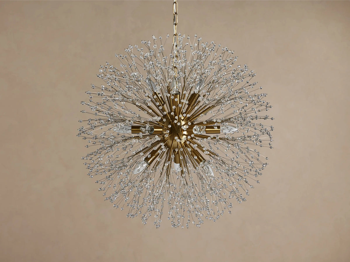 Gold Dandelion Round Chandelier featuring sparkling crystal-tipped arms and illuminated bulbs, against a brown background.
