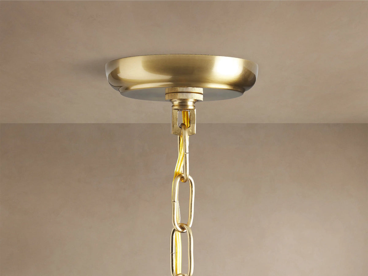 Dandelion Round Chandelier, close-up. Gold-toned central hub, radiating metal arms with clear crystals & warm glowing bulbs.