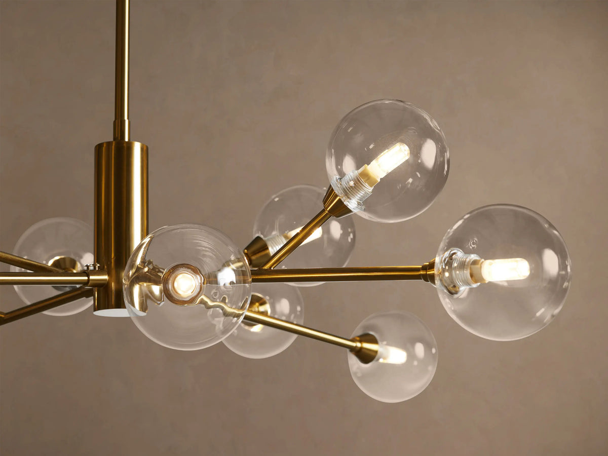 Apollo Round Chandelier with a central rod, plated brass frame, clear glass globe shades, and visible LED bulbs, suspended.