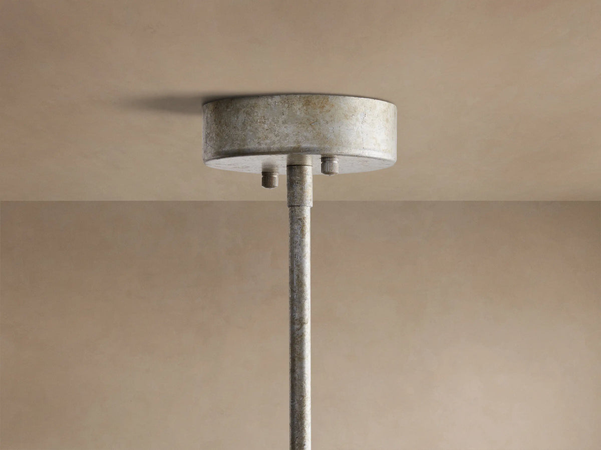 Antique silver-finished round Cameron Chandelier with translucent white selenite panels, glowing with warm light against a beige wall.