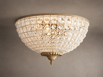 Poppy Flush Mount. Dome-shaped fixture with rows of clear faceted crystals and antique brass accents, glowing warmly on a ceiling.
