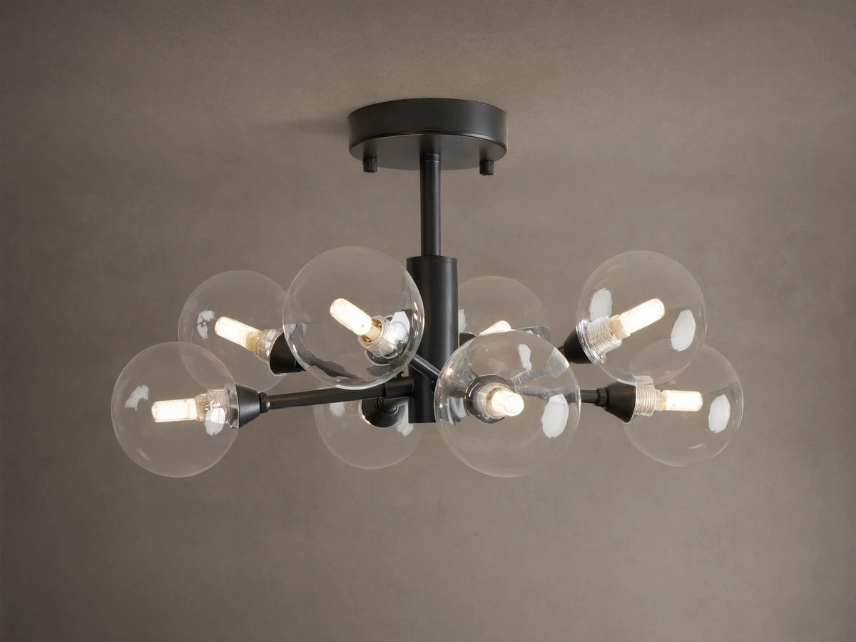 Apollo Flush Mount, dark metal, with eight clear spherical bulbs glowing. Mounted on a light brown ceiling.