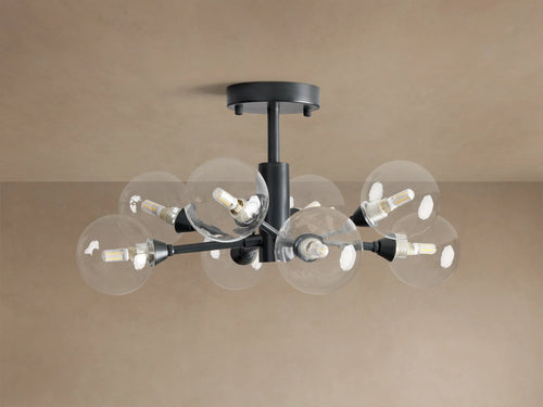 Apollo Flush Mount, dark metal, with eight clear spherical bulbs glowing. Mounted on a light brown ceiling.