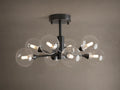 Apollo Flush Mount, dark metal, with eight clear spherical bulbs glowing. Mounted on a light brown ceiling.