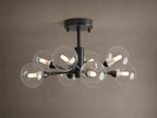 Apollo Flush Mount, dark metal, with eight clear spherical bulbs glowing. Mounted on a light brown ceiling.