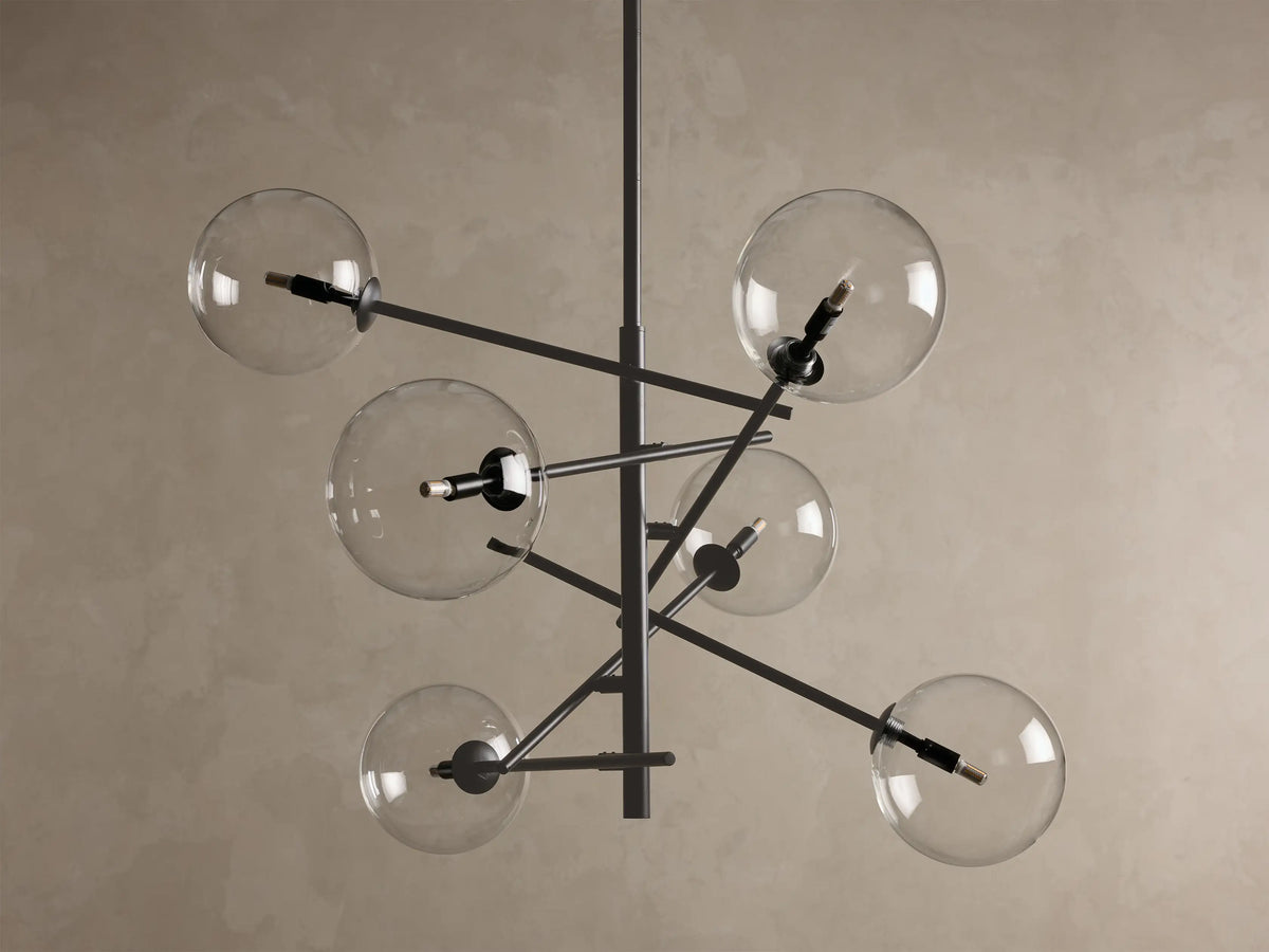 Front view of the bronze Roscoe Chandelier with six clear glass globes extending from a dark, angular central frame. Bulbs are illuminated.