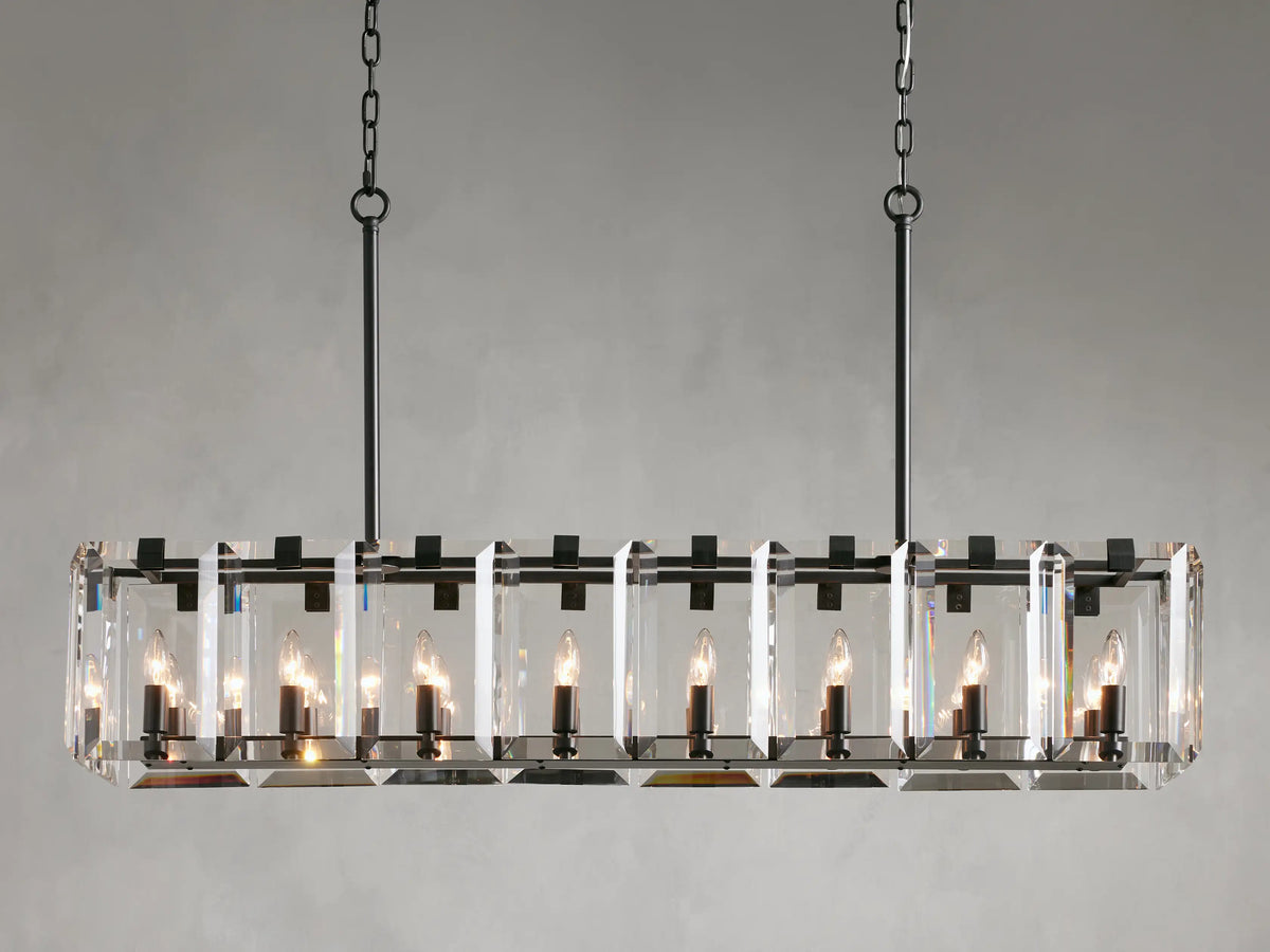 Rectangular chandelier with clear crystal panels and black iron frame, featuring twelve lit candle-style bulbs, hanging from chains.