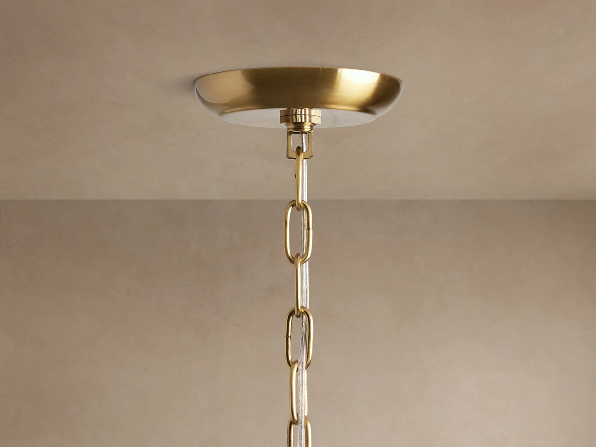 Close-up gold Dandelion Chandelier, radiating spokes adorned with sparkling clear glass crystals and warm glowing bulbs.