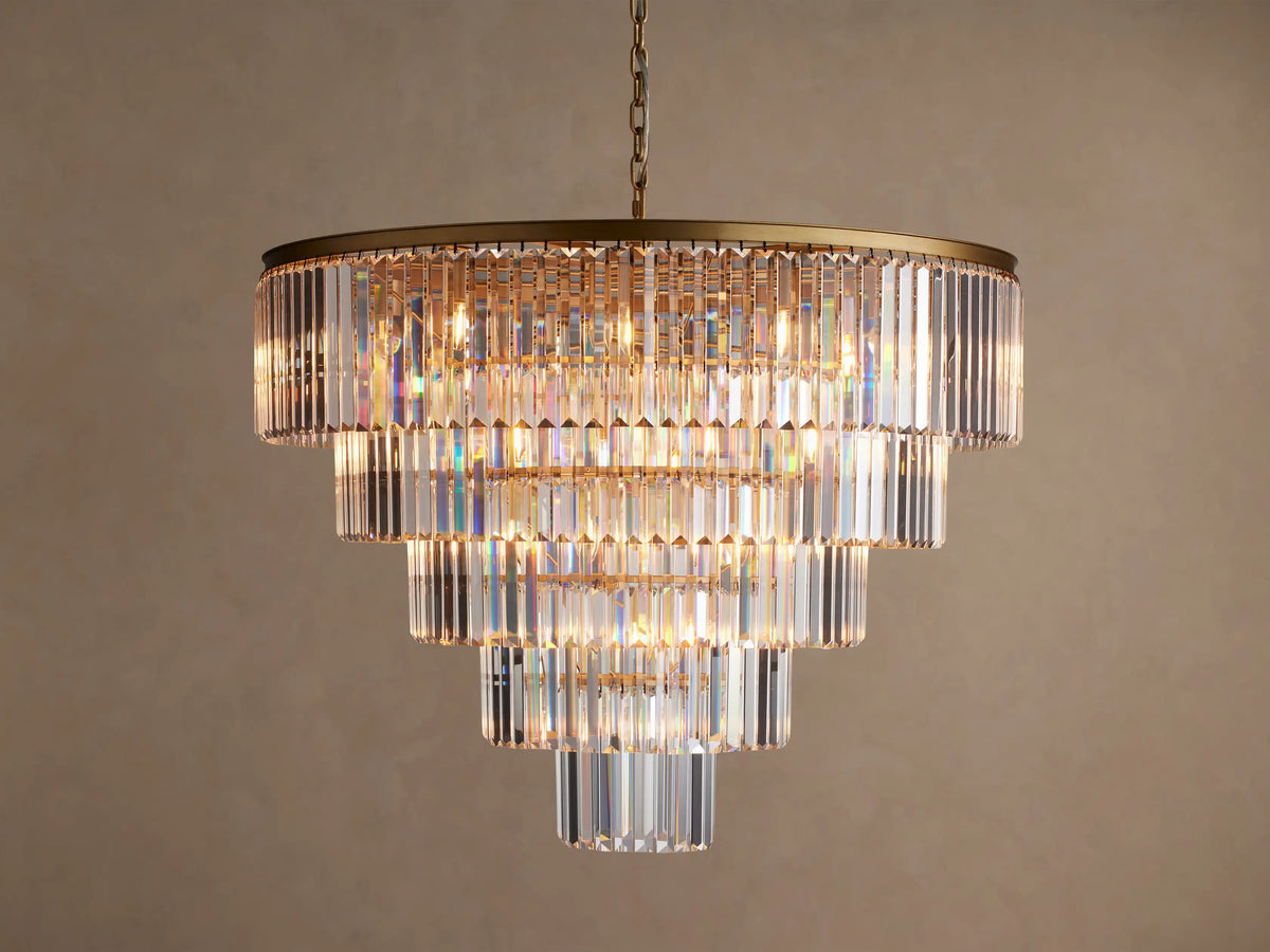 Leyland Tiered Round Chandelier, with multiple layers of rectangular clear K9 crystals glowing warmly, hanging from a dark bronze frame.