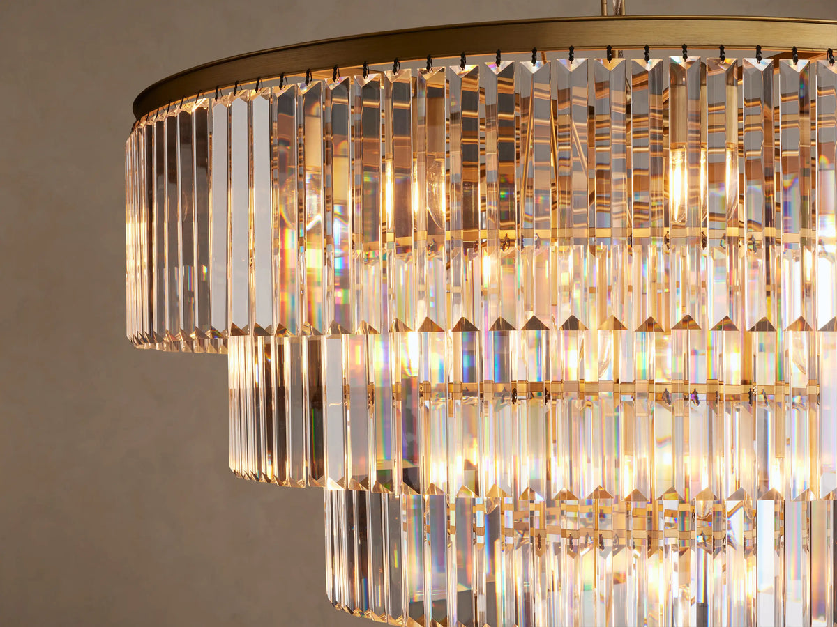 Leyland Tiered Round Chandelier. Multiple concentric tiers of clear K9 crystal rods with a golden frame, shimmering.