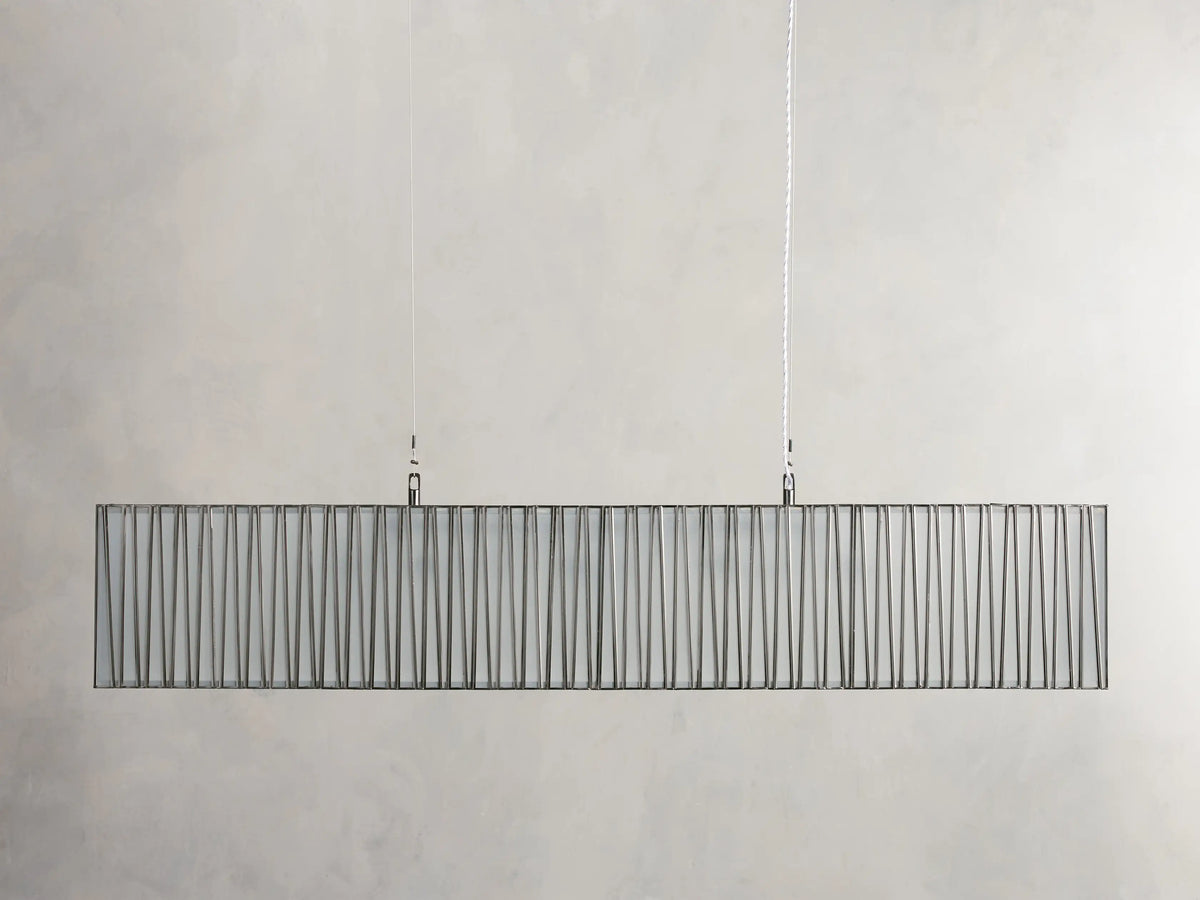 Jeunet Rectangular Chandelier in Nickel, horizontal. Its nickel frame has vertical rods, glowing warm light through a diffuser.