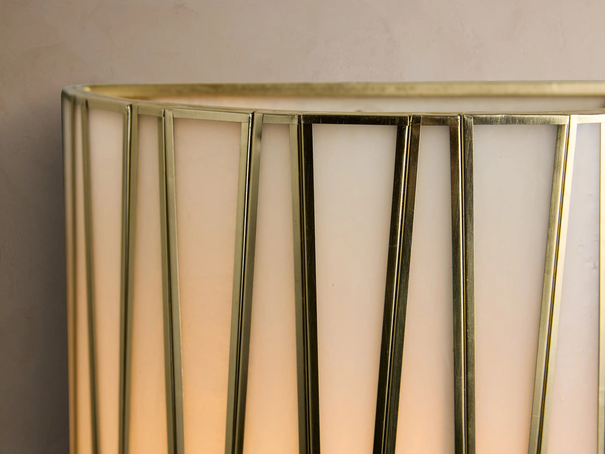 Jeunet Sconce, a long, rectangular wall-mounted light with an antiqued brass geometric frame and milky white glass panels.