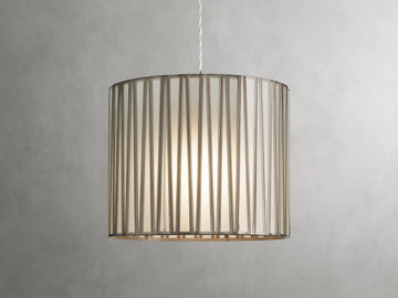 Jeunet Pendant with antiqued brass finish, cylindrical glass and iron shade, emitting soft light, suspended by a clear cord.