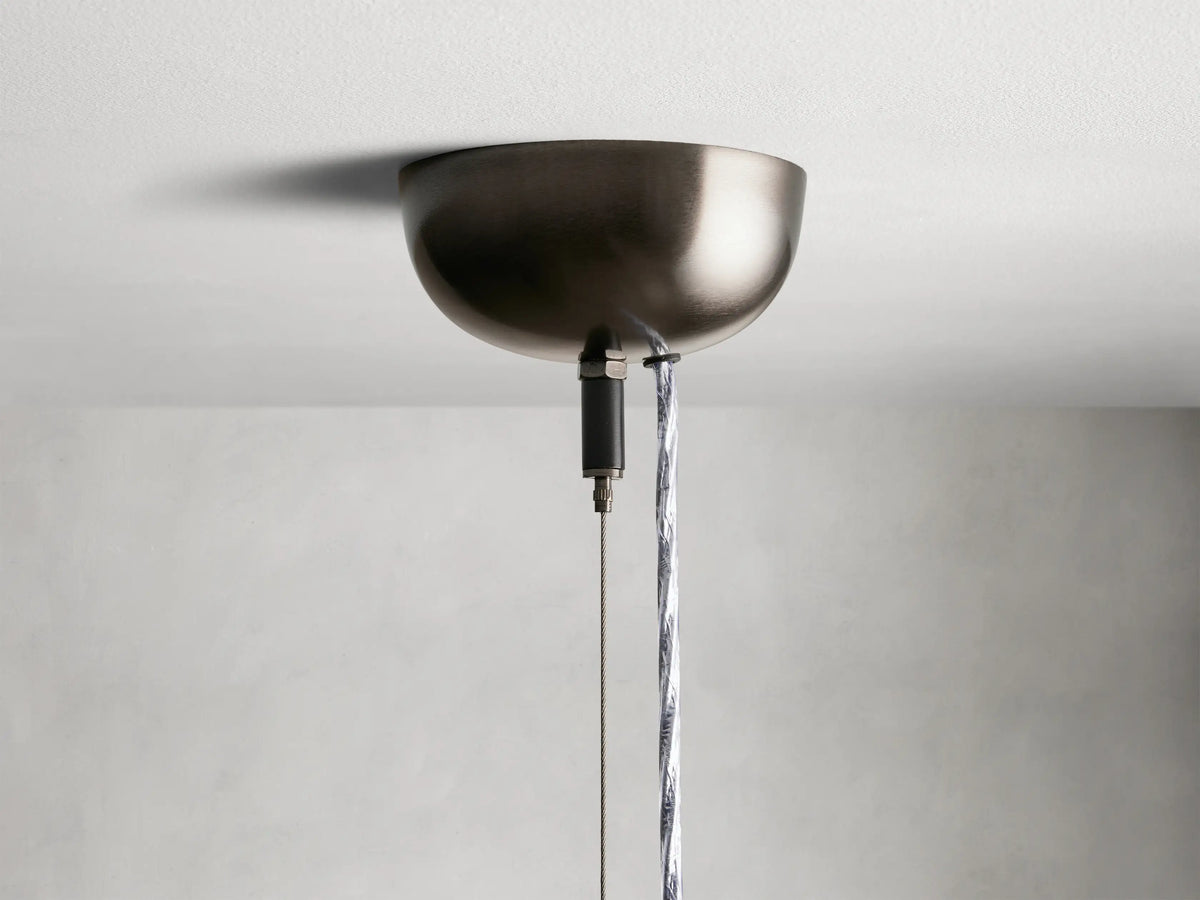 Jeunet Pendant with glass and iron frame in an antiqued brass or nickel finish, showcasing vertical lines against a neutral background.